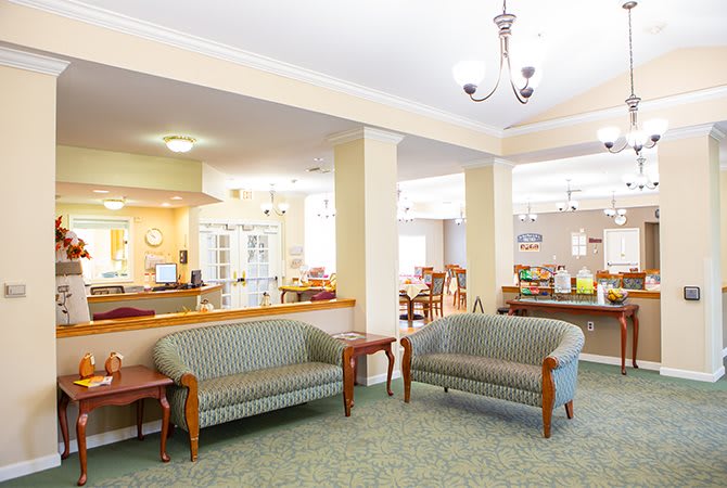 A bright and welcoming lobby with comfortable couches and a chandelier.