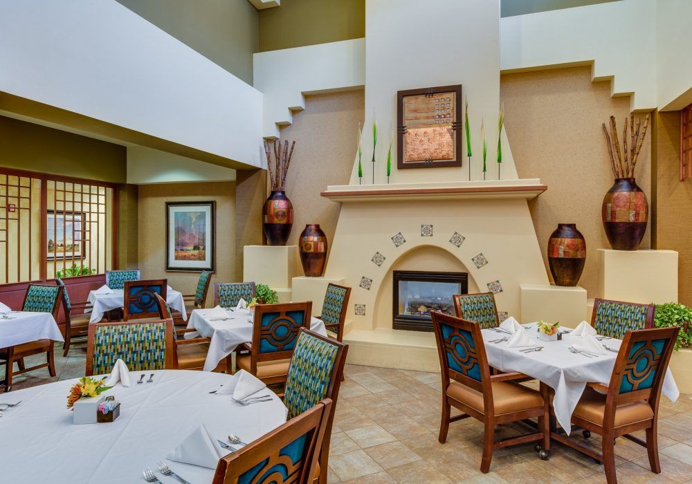 A cozy restaurant dining area with elegantly set tables and a decorative fireplace.