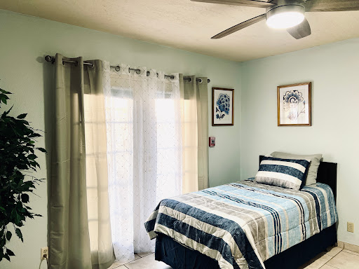 A cozy and inviting bedroom featuring a neatly made bed, soft curtains, and tasteful decor.