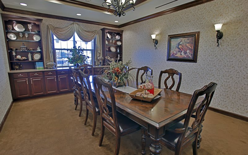 A spacious dining room with a large wooden table and elegant decor.