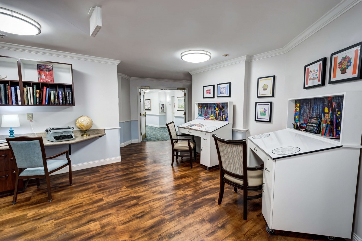 A modern office interior with desks, chairs, and wooden flooring.