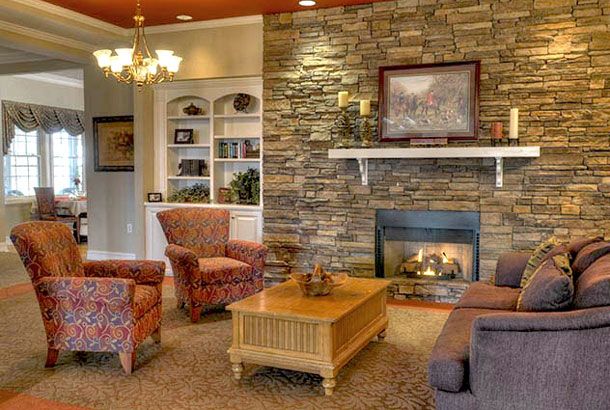 A cozy living room with a stone fireplace and comfortable seating.