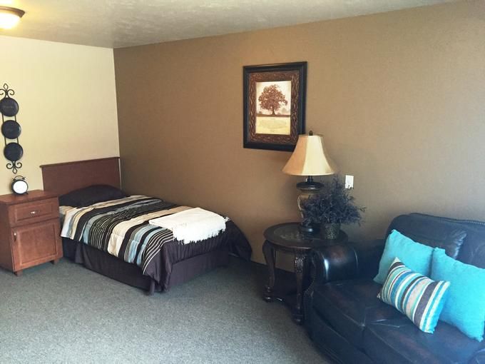 A cozy bedroom with a single bed, side table, and decorative elements.