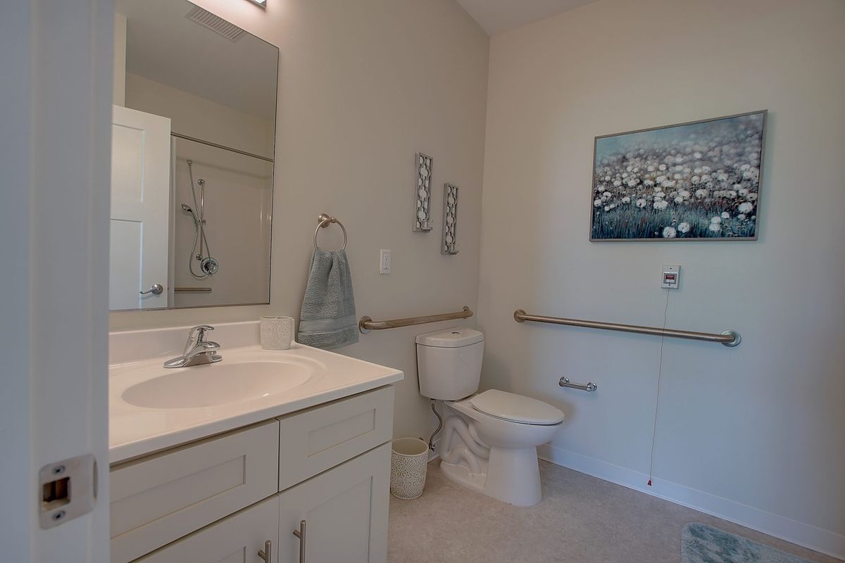 A minimalist bathroom featuring a sink, toilet, and decorative elements.
