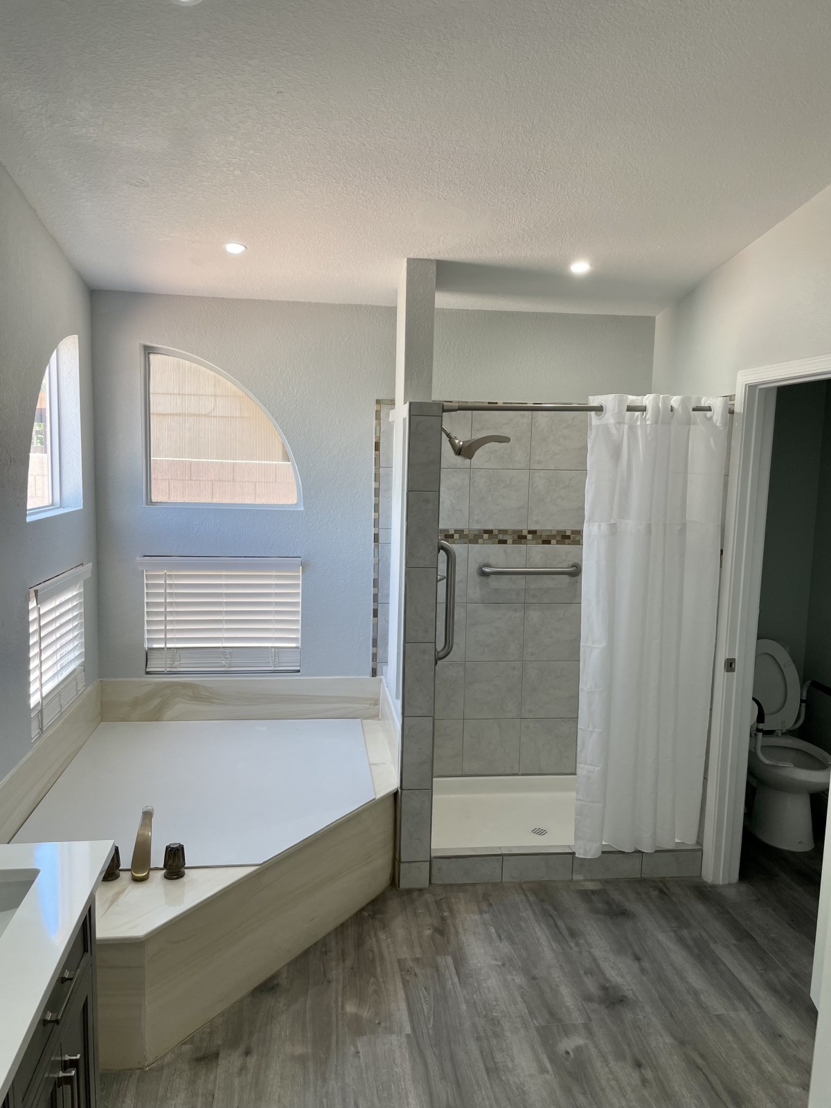 Modern bathroom with a bathtub, shower, and toilet.