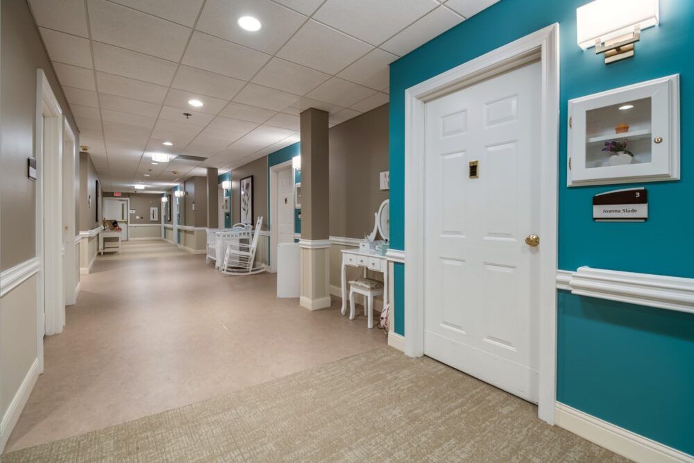 A well-lit hallway with doors and seating areas.