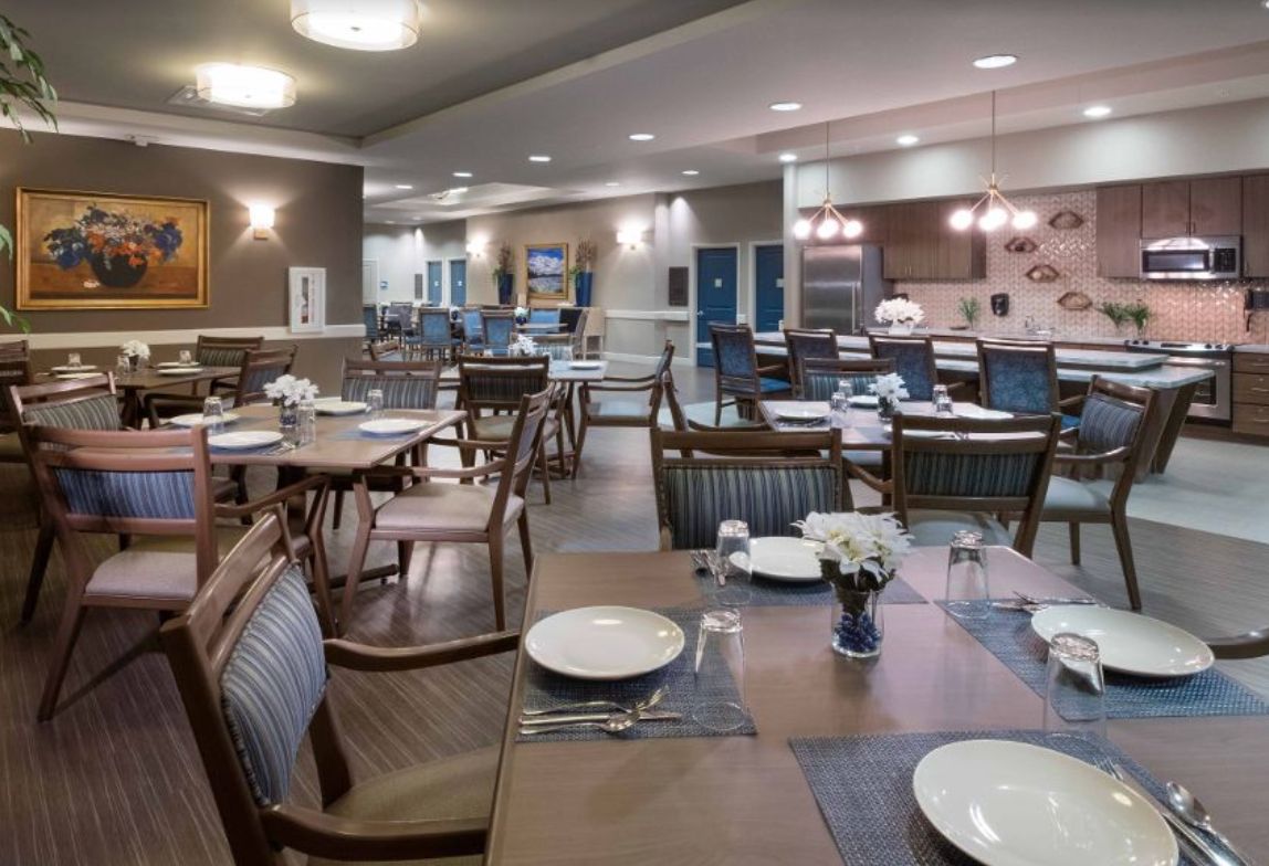 A well-arranged dining area with neatly set tables and chairs, ready for guests.