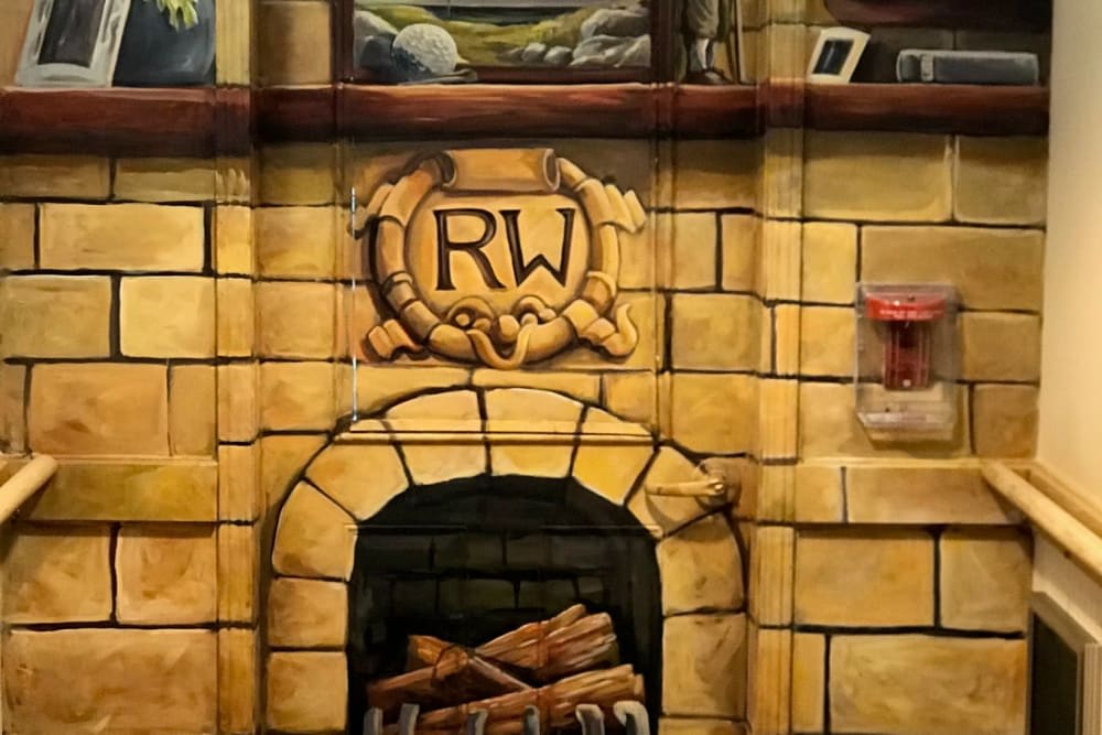 A decorative stone fireplace featuring an 'RW' logo above the hearth.