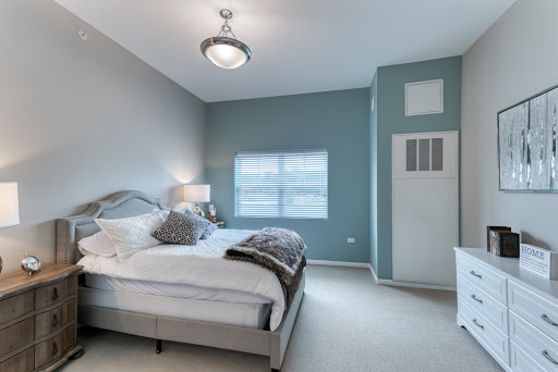A cozy, modern bedroom featuring soft color tones and comfortable furnishings.