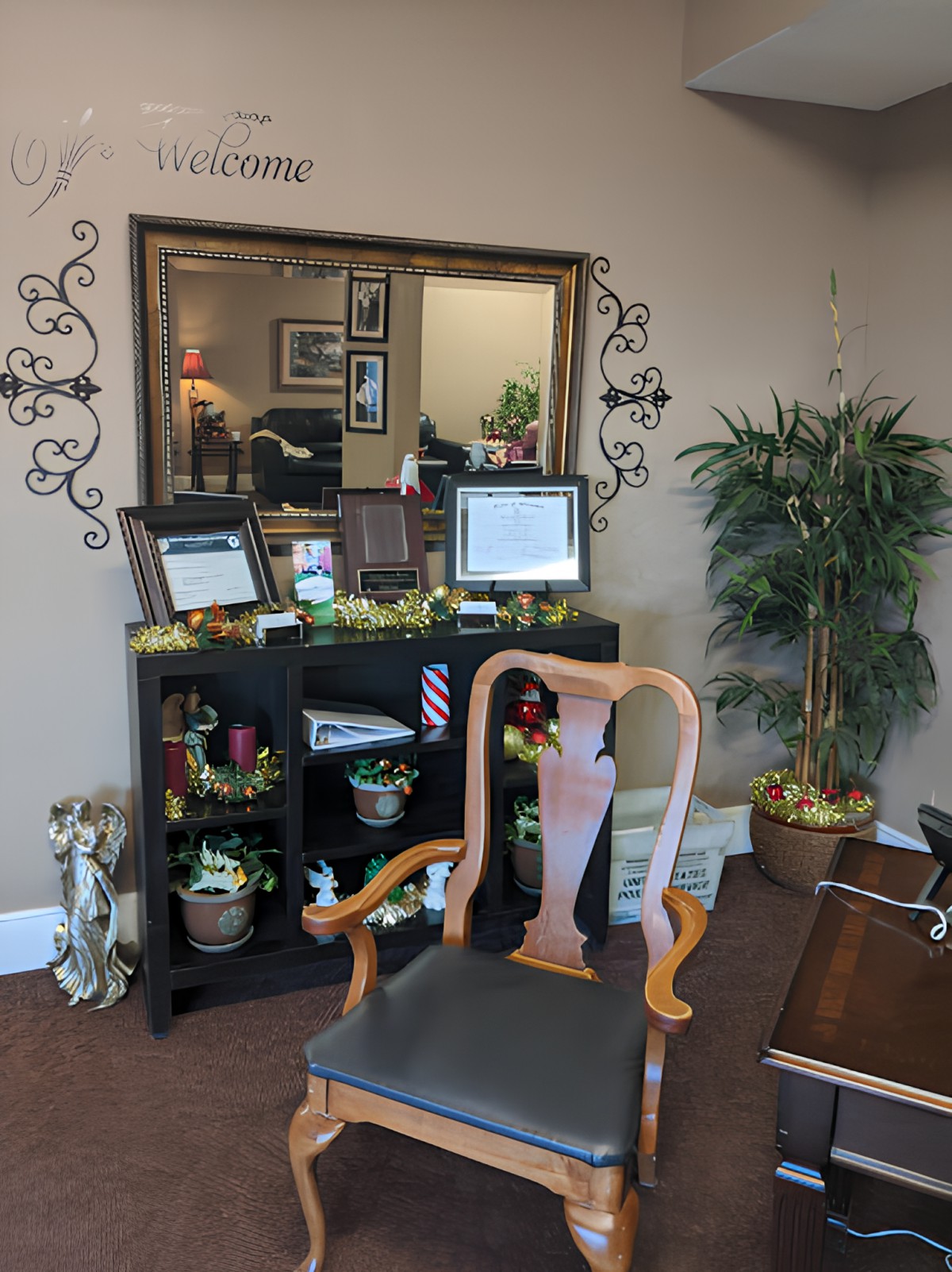 A welcoming reception area with a chair, mirror, and decorative plants.