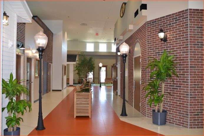 A modern indoor hallway designed to resemble an outdoor street with brick walls and street lamps.