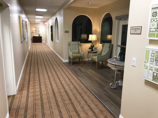 A well-lit hallway featuring cozy seating areas and decorative elements.