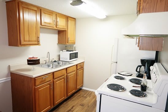 A cozy kitchen with wooden cabinets, white appliances, and a clean countertop.