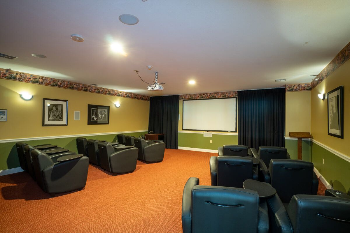 A cozy home theater room with comfortable seating and a large projector screen.