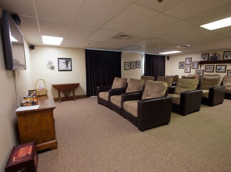A cozy home theater with multiple rows of comfortable seating and a large screen.