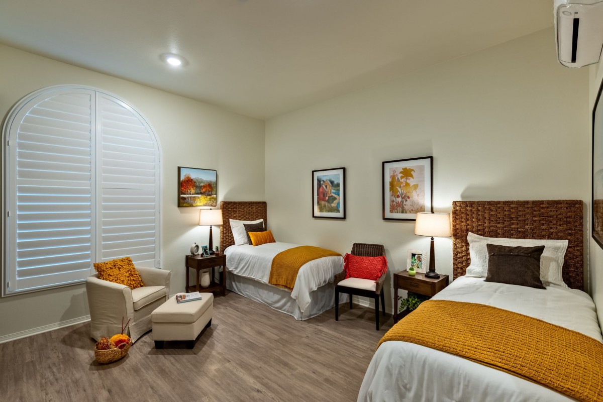 A cozy bedroom with twin beds, tasteful decor, and warm lighting.
