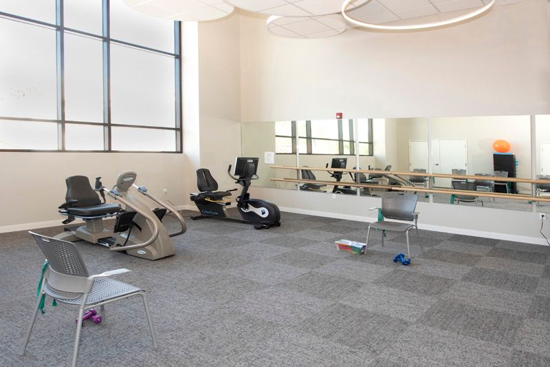 A clean and minimalistic gym with exercise equipment including stationary bikes.