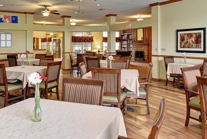 A spacious dining room with neatly arranged tables and chairs, featuring a warm and inviting interior design.