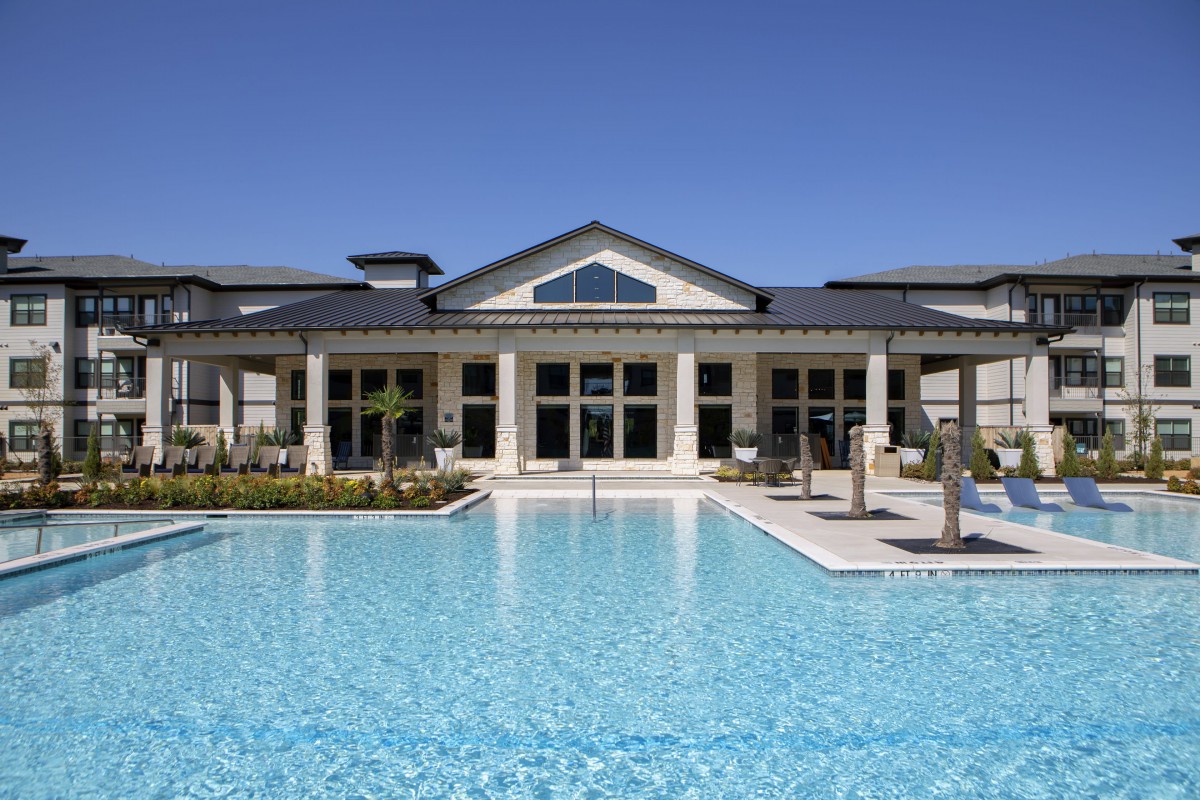A luxurious resort building with a large outdoor swimming pool.