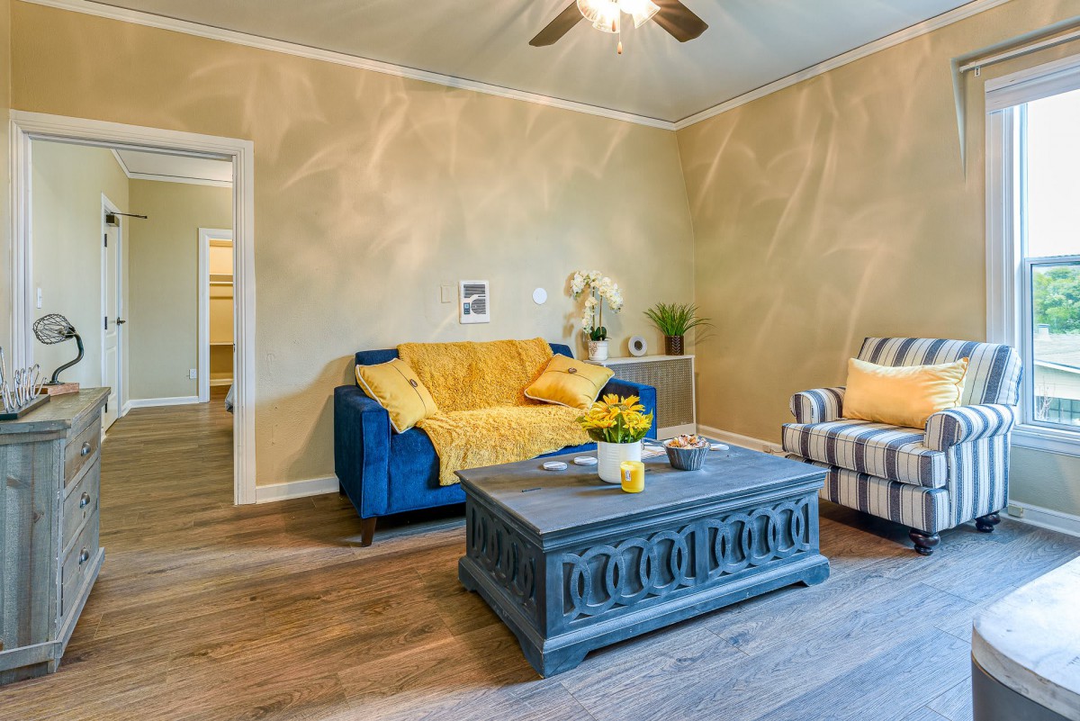 Cozy living room with a blue sofa, striped armchair, and wooden coffee table.