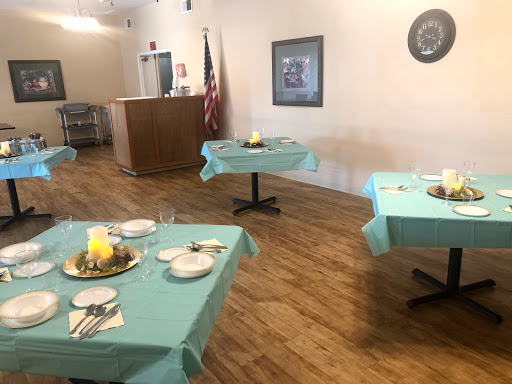 A spacious dining area set up with turquoise tablecloths, ready for a gathering or event.