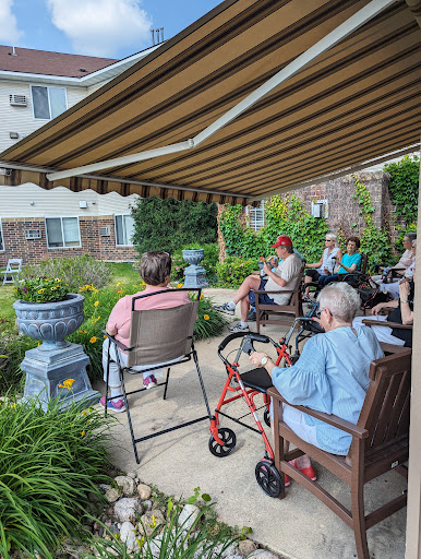 A group of elderly individuals enjoying a sunny day in the garden.