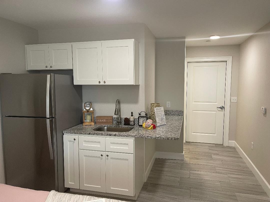 A modern kitchen with white cabinets and stainless steel appliances.