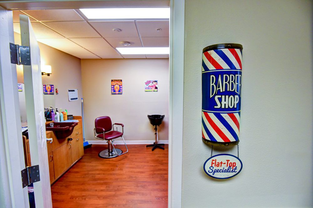 An interior view of a barber shop featuring a traditional barber pole and barbershop chair.