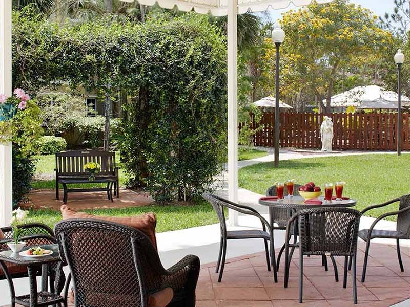 A serene patio area with outdoor seating surrounded by lush greenery.