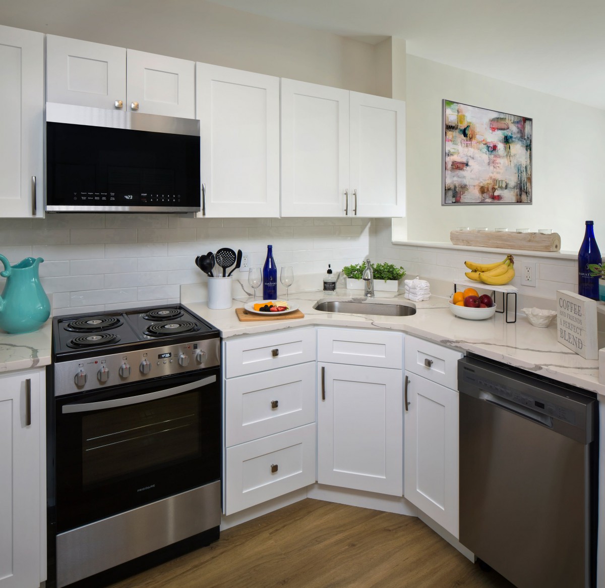 A modern kitchen with white cabinets and stainless steel appliances.