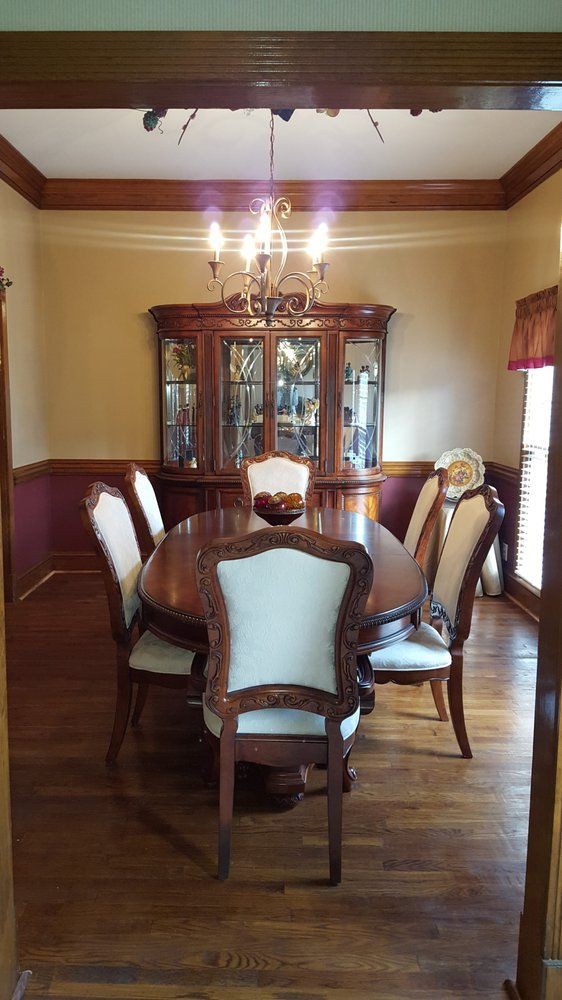 An elegant dining room with a wooden table and chairs, complemented by a china cabinet and chandelier.