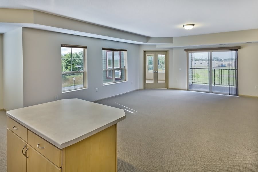 An empty apartment living room featuring large windows and ample natural light.