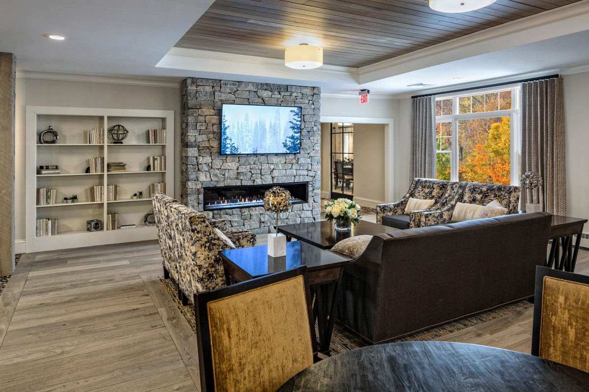 A cozy living room featuring a stone fireplace and modern decor.