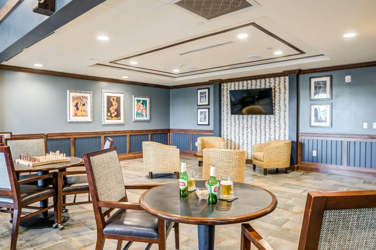 A comfortable lounge area with tables, chairs, and artwork on the walls.