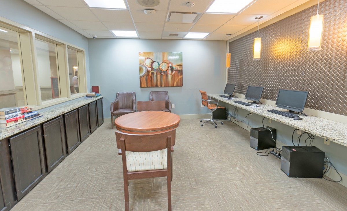 Modern office workspace with computers and seating area.