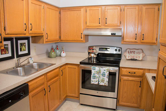 A modern kitchen with wooden cabinets and stainless steel appliances.