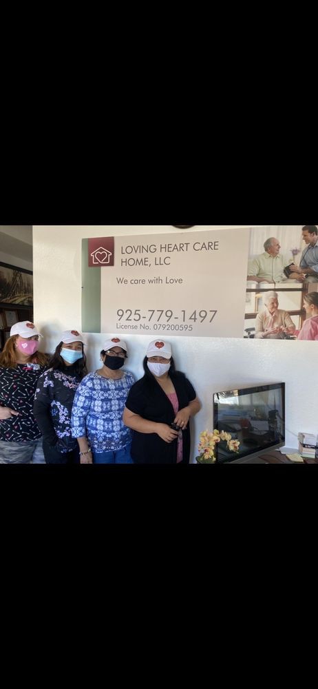 A group of people posing in front of a care home welcome sign.