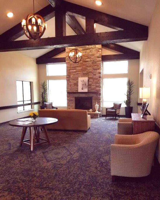 A cozy living room with a stone fireplace, comfortable seating, and elegant decor.