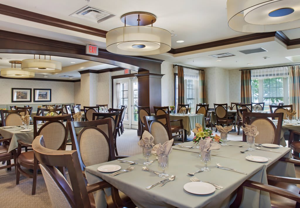 An elegant dining room with neatly arranged tables and chairs, ready to host guests.