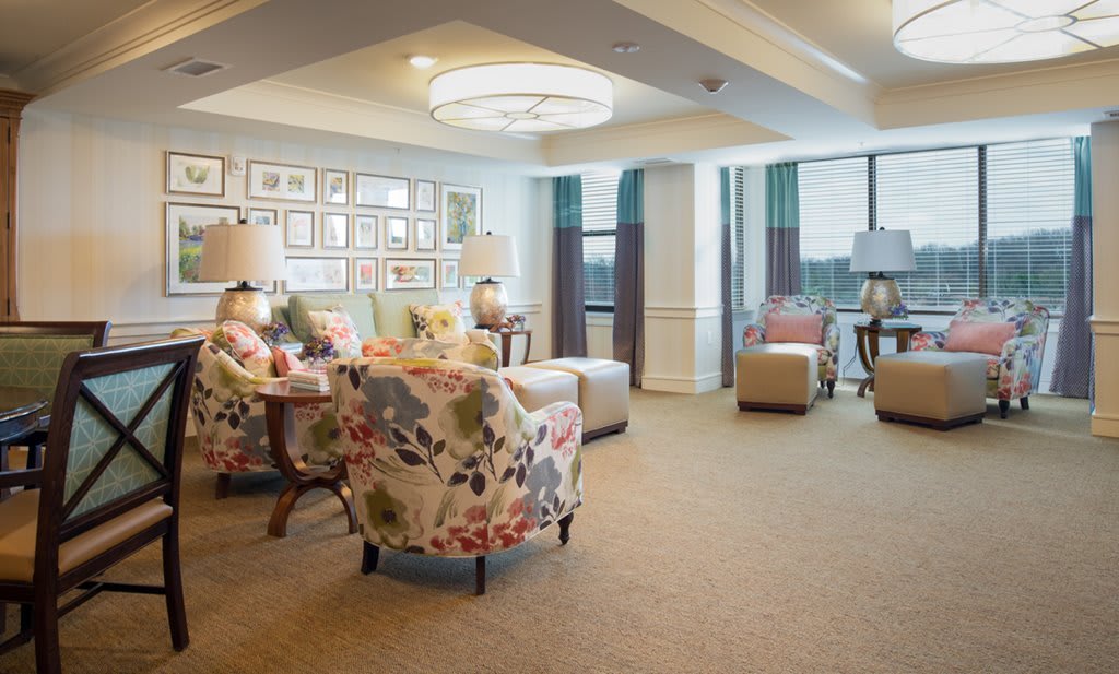 A cozy lounge with floral chairs and modern lighting.