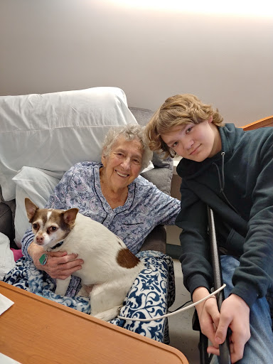 A heartwarming moment shared between a grandmother, her grandson, and their beloved dog.