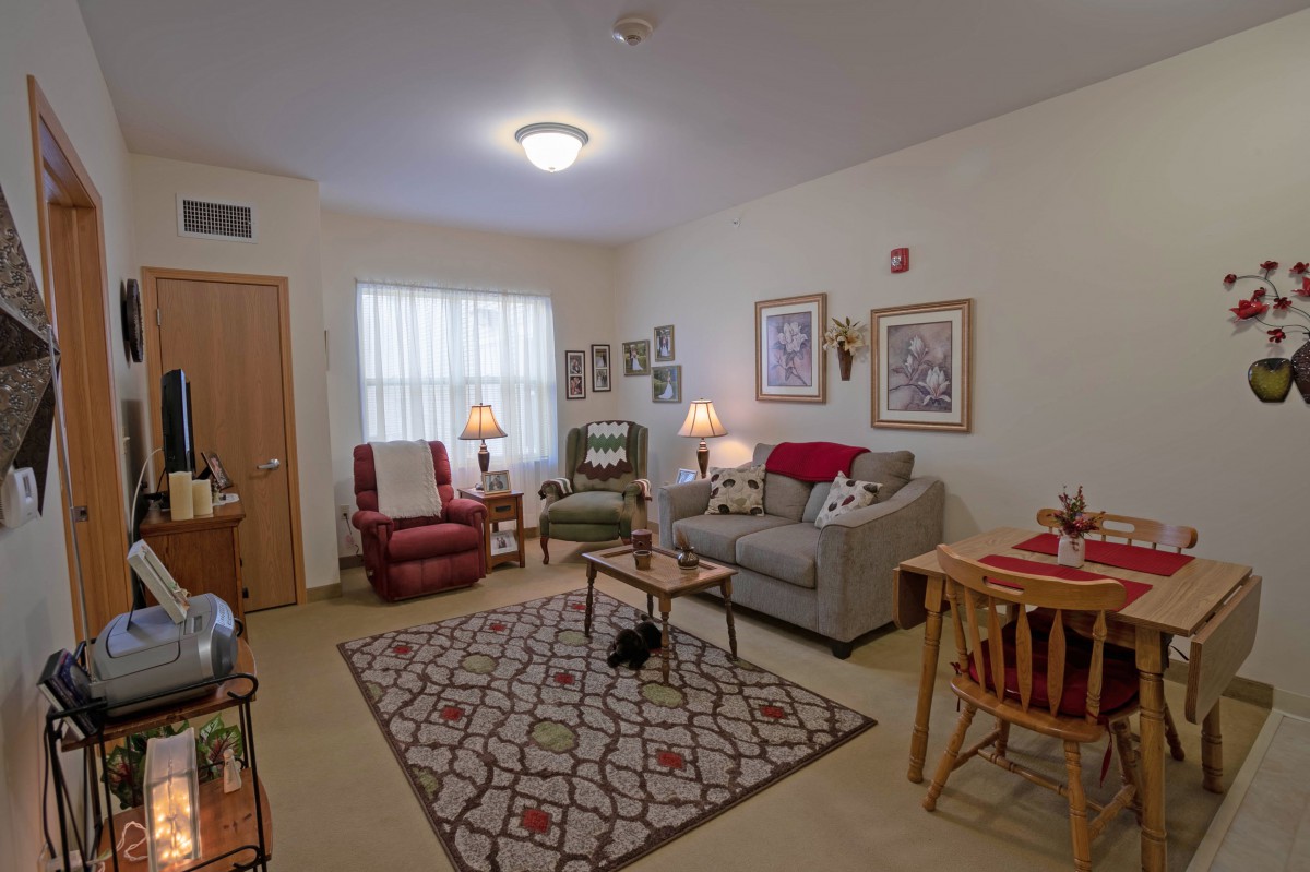 A cozy living room with a sofa, armchairs, and decorative elements creating a warm atmosphere.