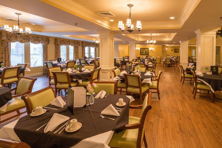 An elegantly set dining room with neatly arranged tables and chairs, ready for guests.