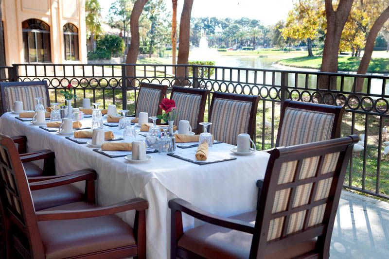 An elegantly set outdoor dining table on a patio with scenic views.
