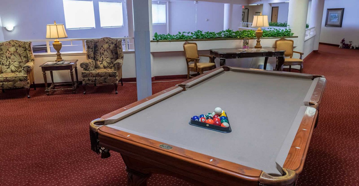 A pool table set up in a cozy game room environment.