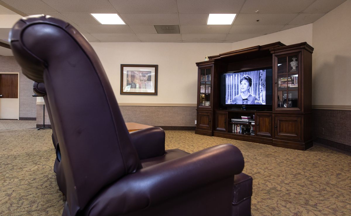 A cozy living room with a large TV and comfortable leather seating.