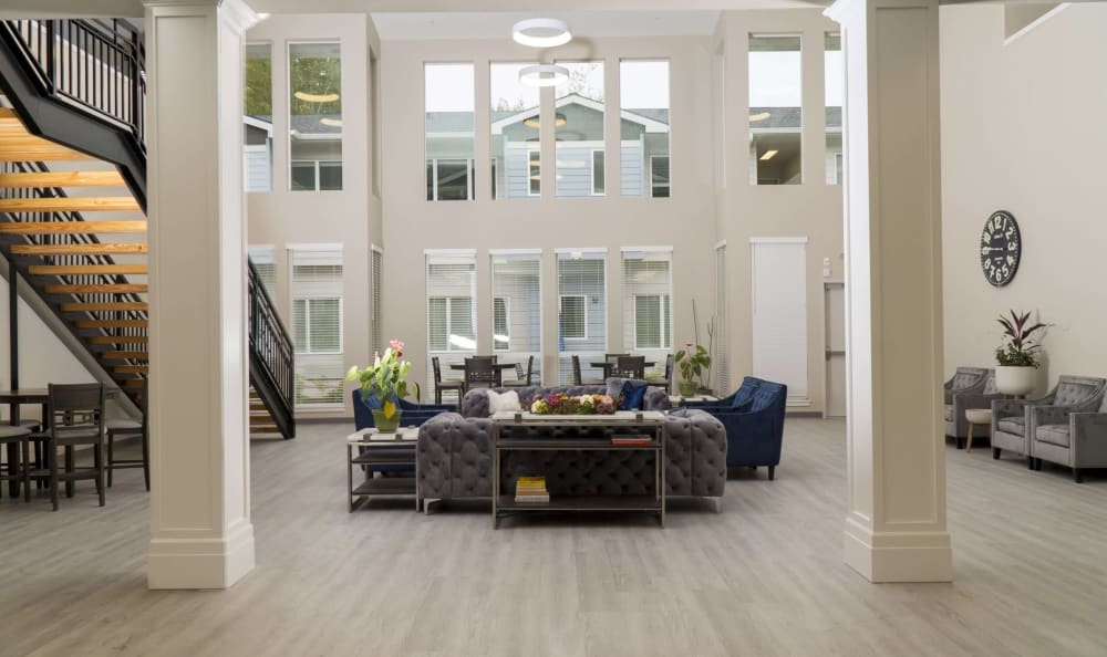 A spacious living room featuring modern furniture and large windows allowing ample natural light.