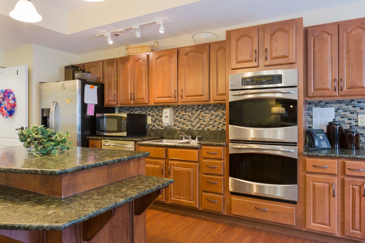 Modern kitchen with wooden cabinets and double ovens.