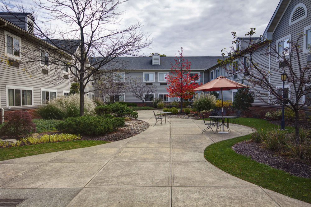 A serene courtyard with pathways, landscaping, and outdoor seating.