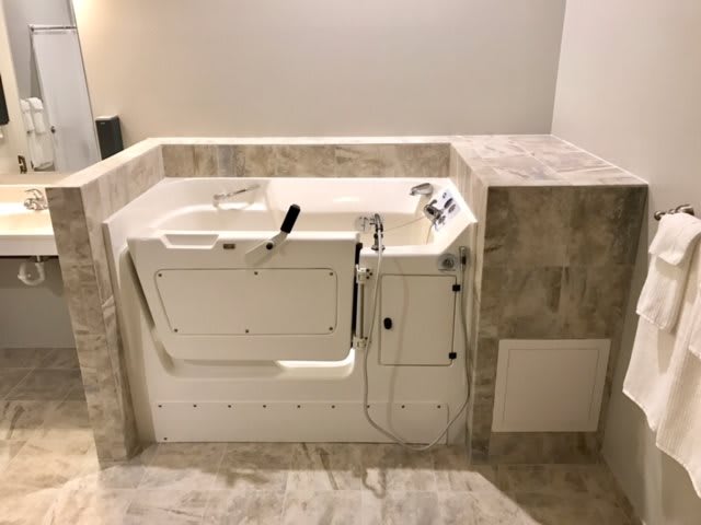 A modern walk-in bathtub in a bathroom with a focus on accessible design.